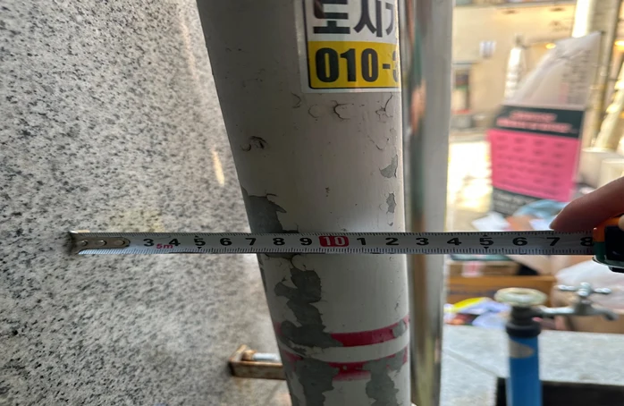 외벽 가스관 끝선에서 약 13cm 이격을 실측한 모습 — 펜스와 가스관 접촉·간섭 없이 위치 결정